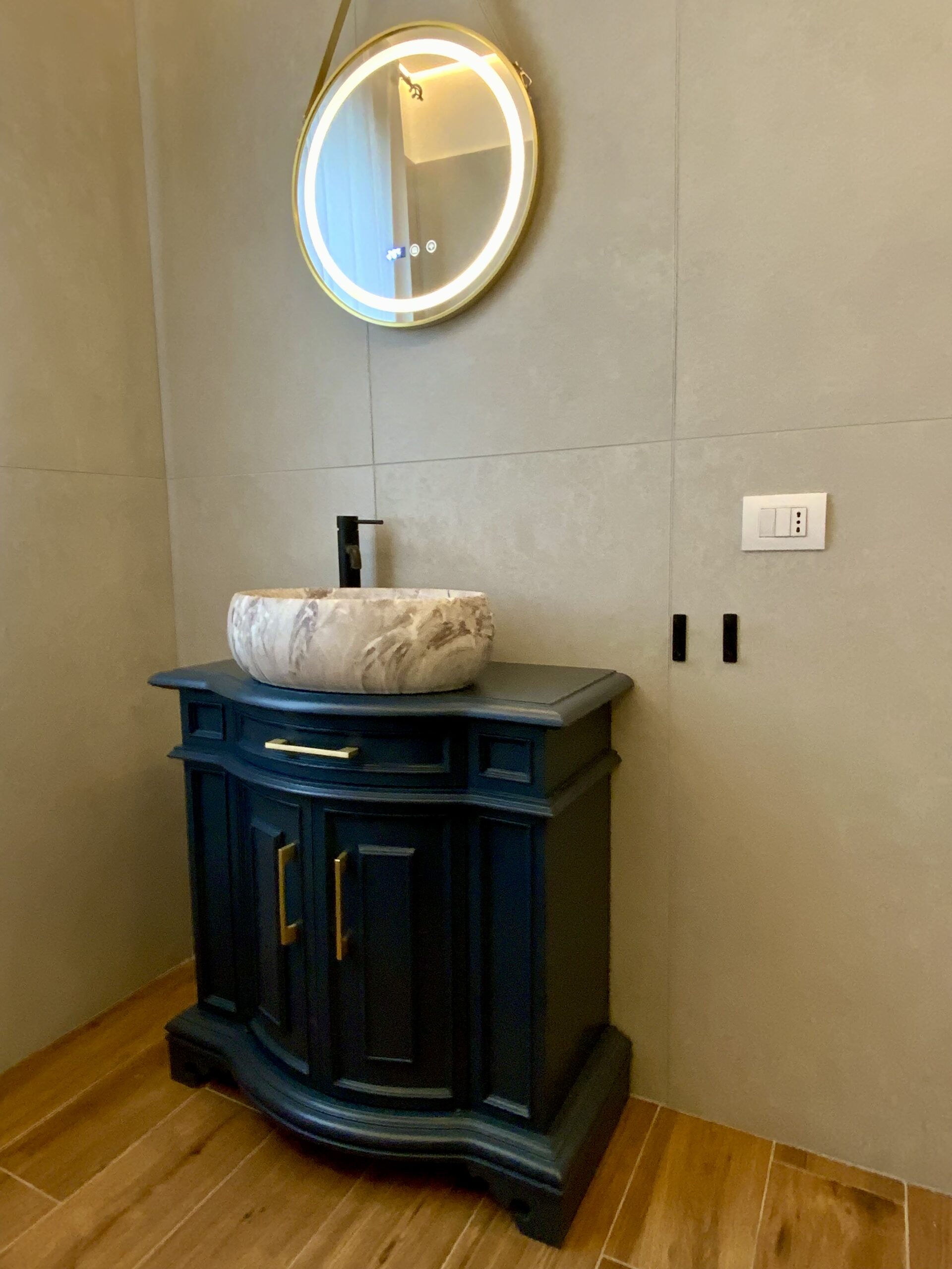 Dettaglio del mobile bagno restaurato con lavabo in pietra