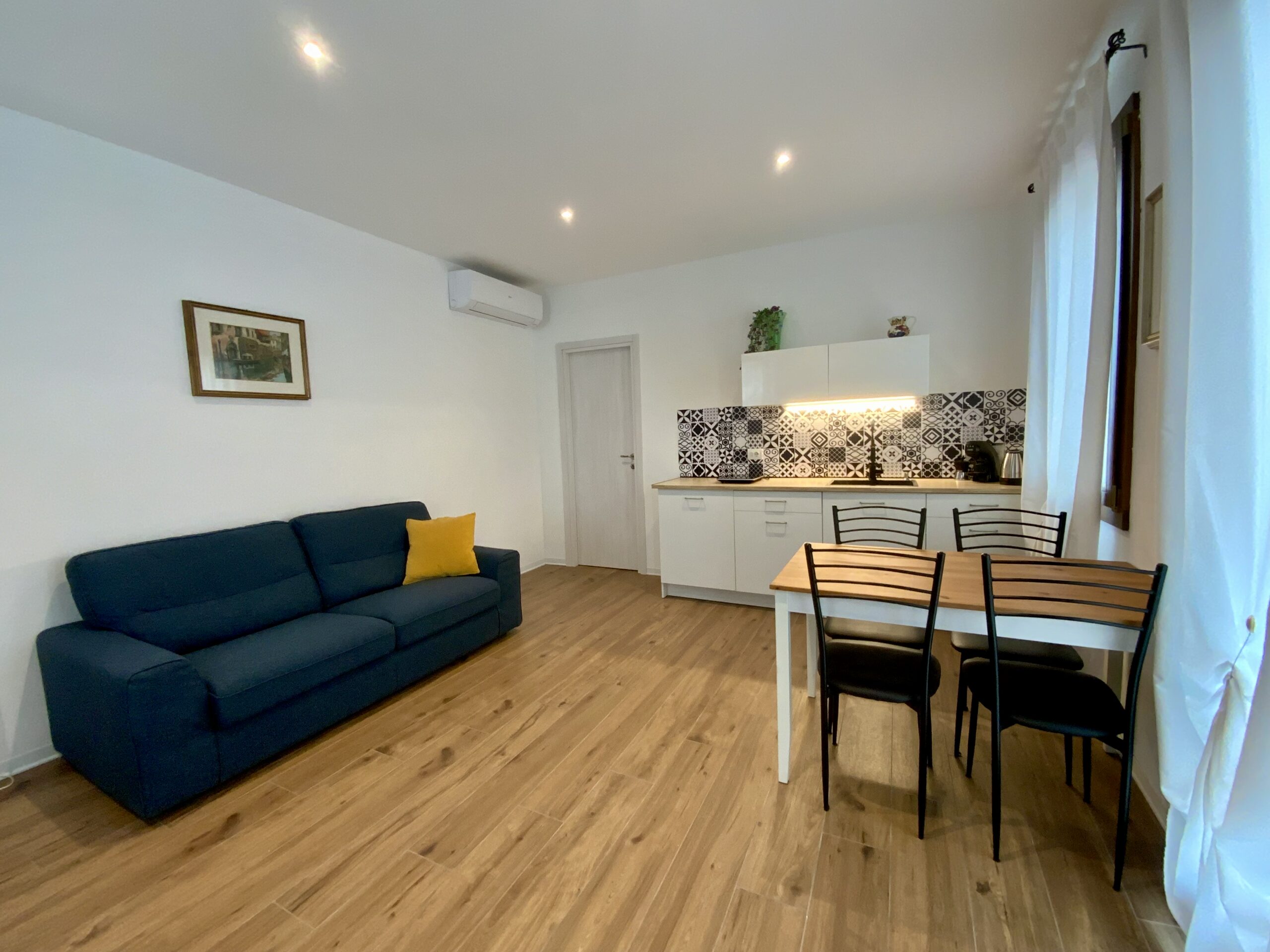 Zona relax con divano blu nella Suite Romantica di Villa Venezia