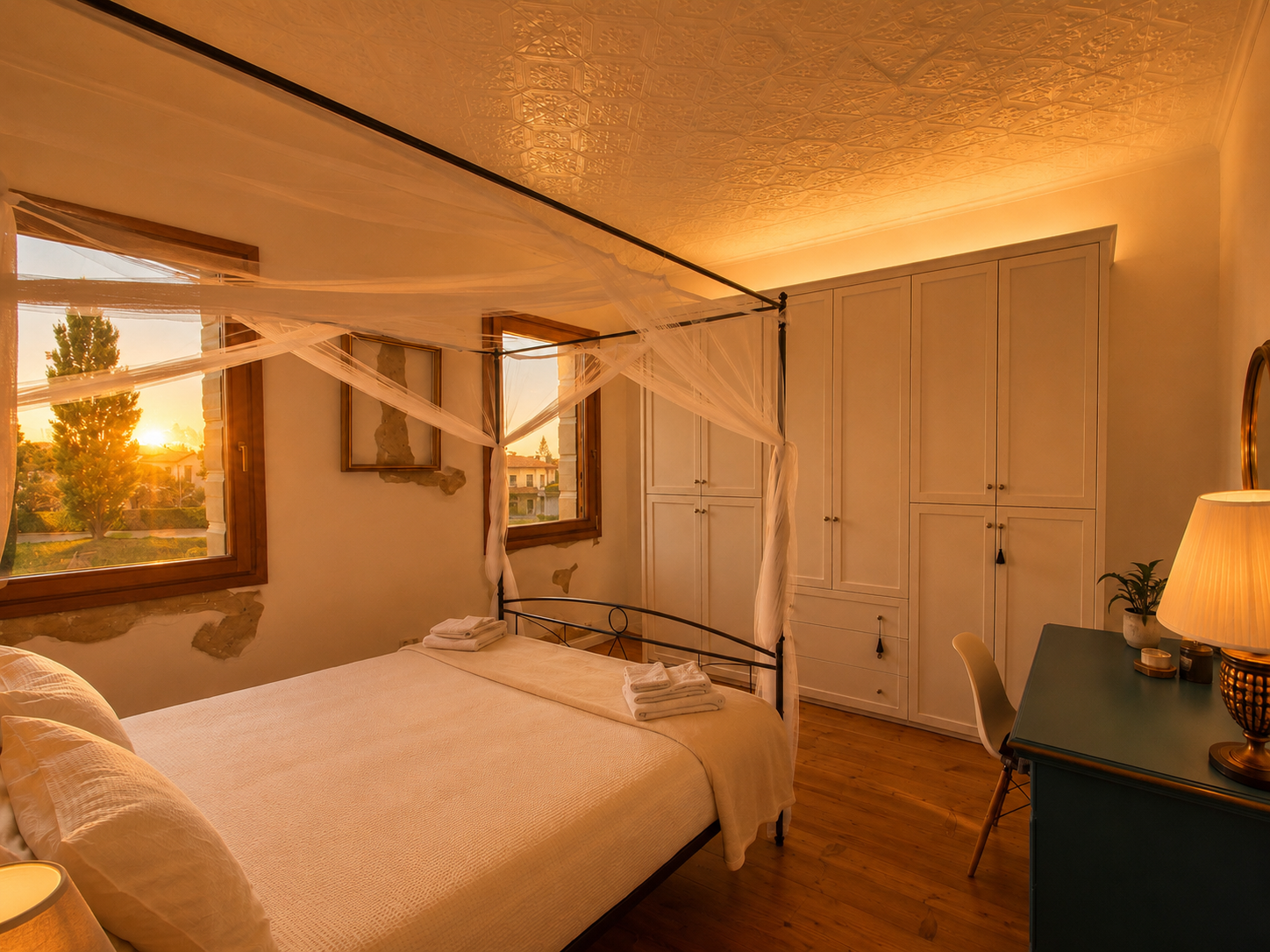 Camera matrimoniale con letto a baldacchino di Villa Venezia illuminata dalla luce del tramonto