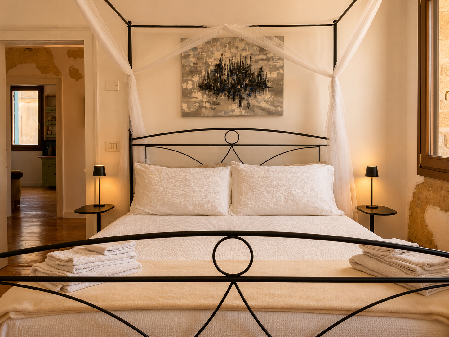 Letto matrimoniale a baldacchino con biancheria bianca nella camera di Villa Venezia